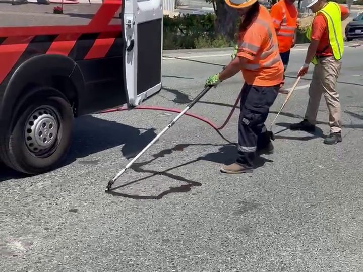 Perma-Patch service van marked Road Pros Know What Works with an operator finishing a cold-pour crack seal
